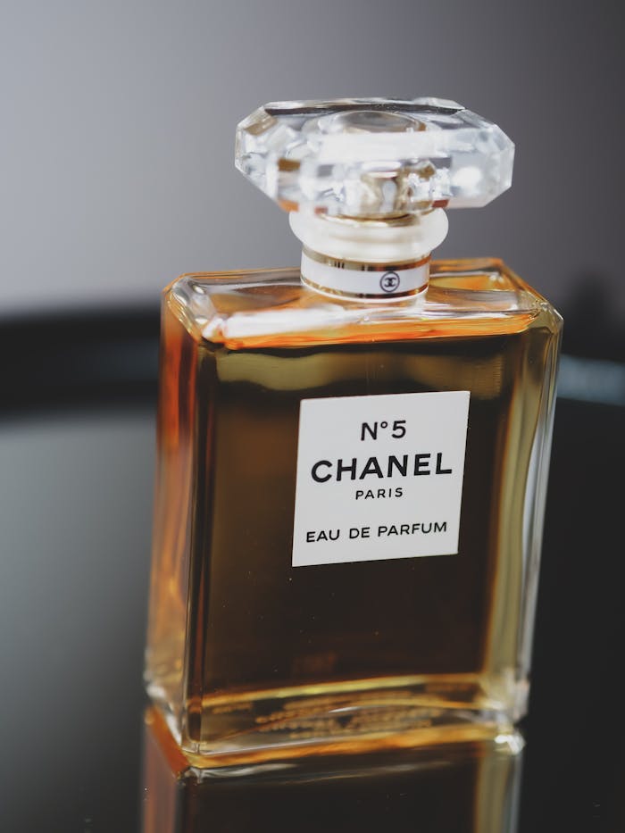 Close-up of an elegant perfume bottle with crystal lid on a reflective surface.