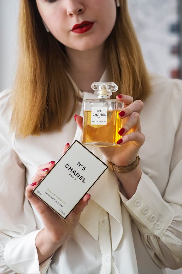 The Art of Drawing Readers In: Your attractive post title goes here Woman displaying Chanel No.5 perfume against a neutral background with elegant attire.
