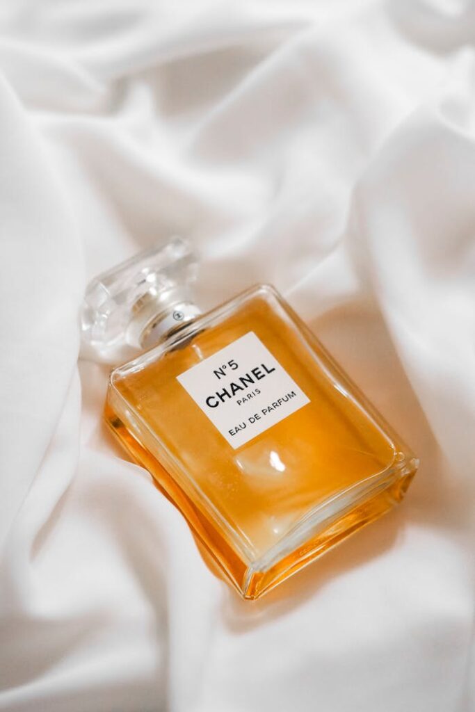 Elegant perfume bottle placed on delicate white fabric, showcasing luxury and style.